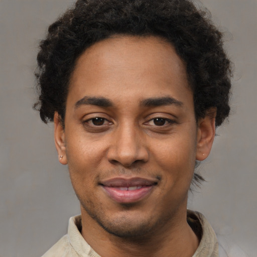 Joyful black young-adult male with short  black hair and brown eyes