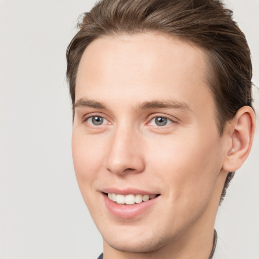 Joyful white young-adult male with short  brown hair and grey eyes