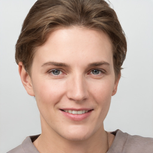 Joyful white young-adult female with short  brown hair and grey eyes