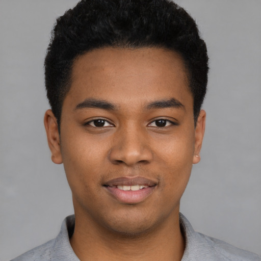 Joyful black young-adult male with short  black hair and brown eyes
