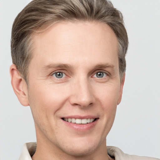 Joyful white adult male with short  brown hair and grey eyes