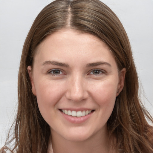 Joyful white young-adult female with long  brown hair and grey eyes