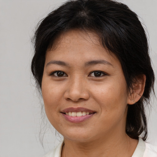 Joyful asian adult female with medium  brown hair and brown eyes