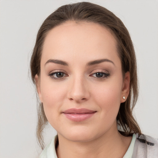 Joyful white young-adult female with medium  brown hair and grey eyes