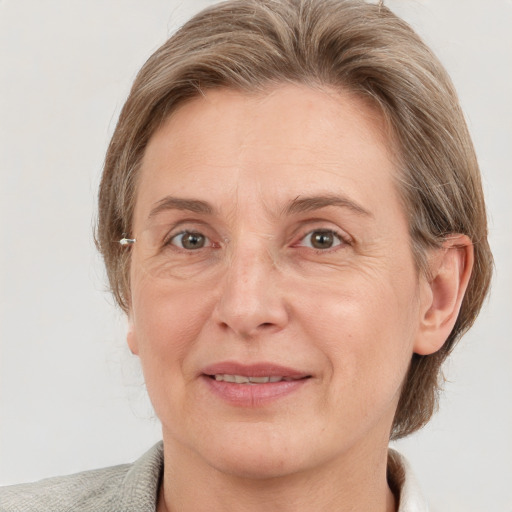 Joyful white adult female with medium  brown hair and grey eyes