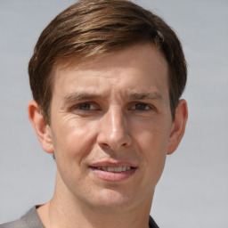 Joyful white adult male with short  brown hair and grey eyes