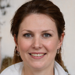 Joyful white young-adult female with medium  brown hair and blue eyes