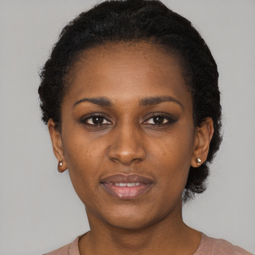 Joyful black young-adult female with short  black hair and brown eyes