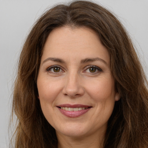 Joyful white adult female with long  brown hair and brown eyes