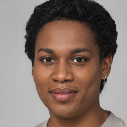 Joyful black young-adult female with short  black hair and brown eyes
