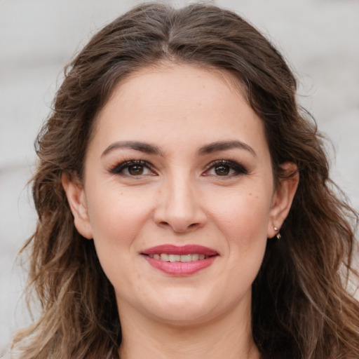 Joyful white young-adult female with long  brown hair and brown eyes