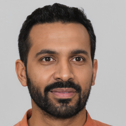 Joyful latino young-adult male with short  black hair and brown eyes