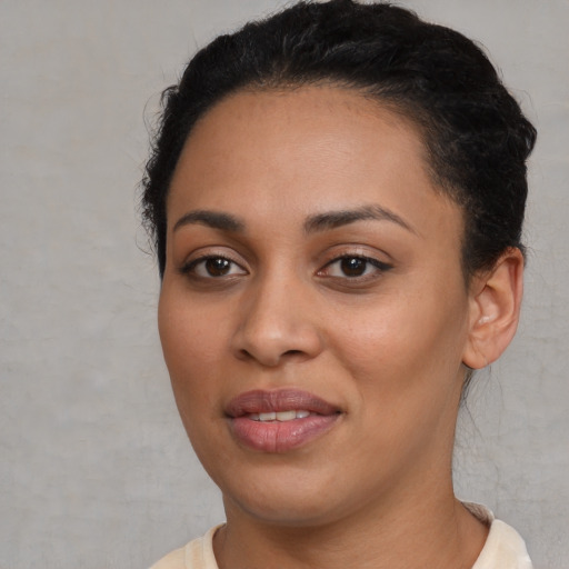 Joyful black young-adult female with short  black hair and brown eyes