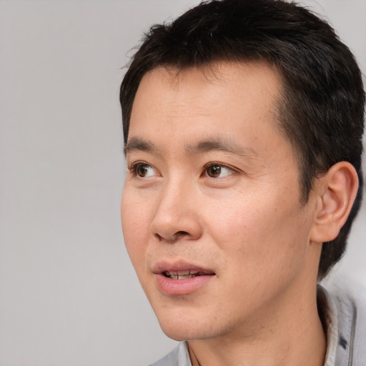 Joyful white adult male with short  black hair and brown eyes