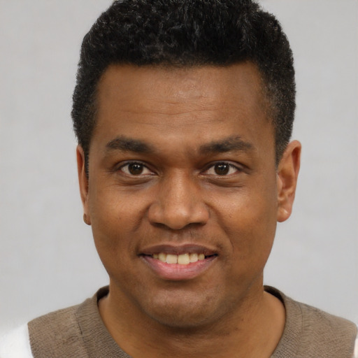 Joyful black young-adult male with short  black hair and brown eyes