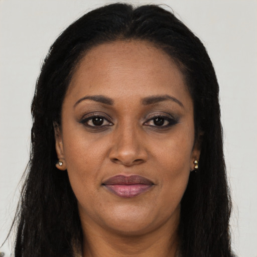 Joyful black adult female with long  black hair and brown eyes