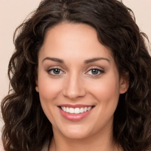 Joyful white young-adult female with long  brown hair and brown eyes