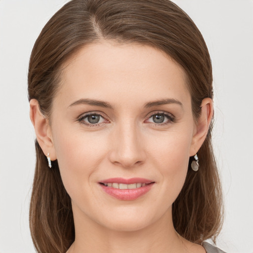 Joyful white young-adult female with medium  brown hair and grey eyes