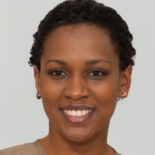 Joyful black young-adult female with short  brown hair and brown eyes