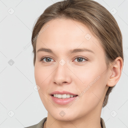 Joyful white young-adult female with medium  brown hair and grey eyes