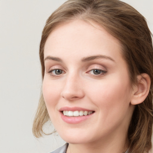 Joyful white young-adult female with long  brown hair and blue eyes