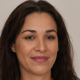 Joyful white adult female with long  brown hair and brown eyes