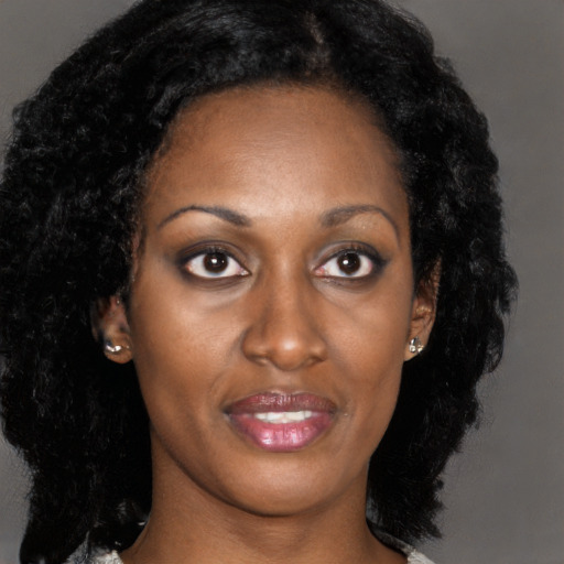 Joyful black young-adult female with long  black hair and brown eyes
