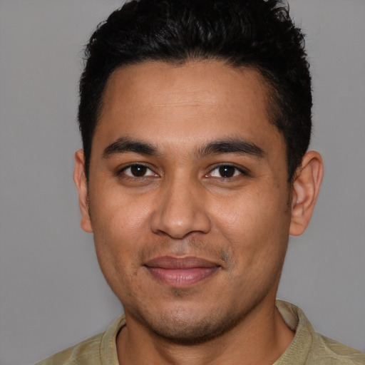 Joyful latino young-adult male with short  brown hair and brown eyes