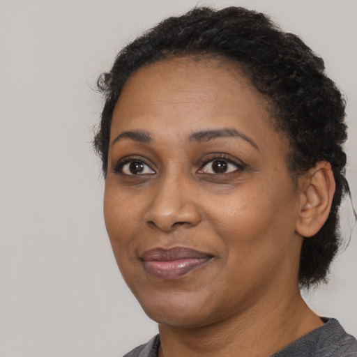 Joyful black adult female with medium  black hair and brown eyes
