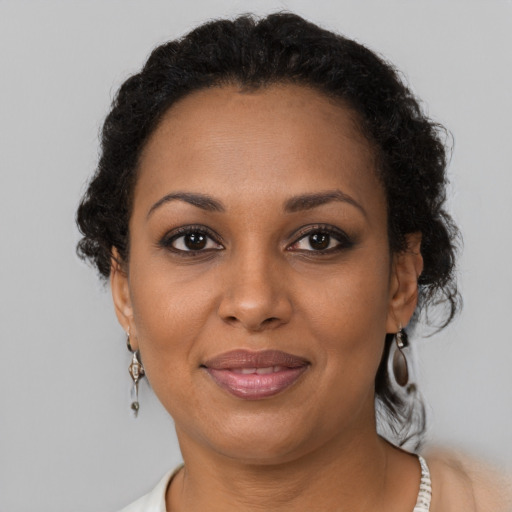 Joyful black adult female with short  brown hair and brown eyes