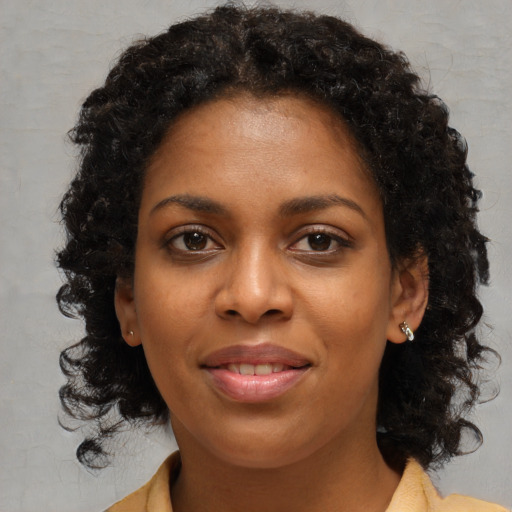 Joyful black young-adult female with medium  brown hair and brown eyes