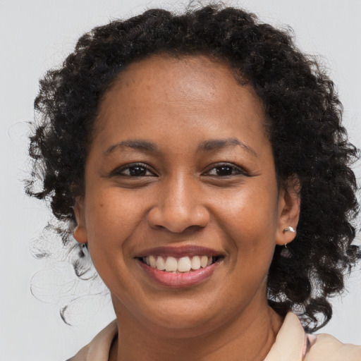 Joyful black adult female with long  brown hair and brown eyes