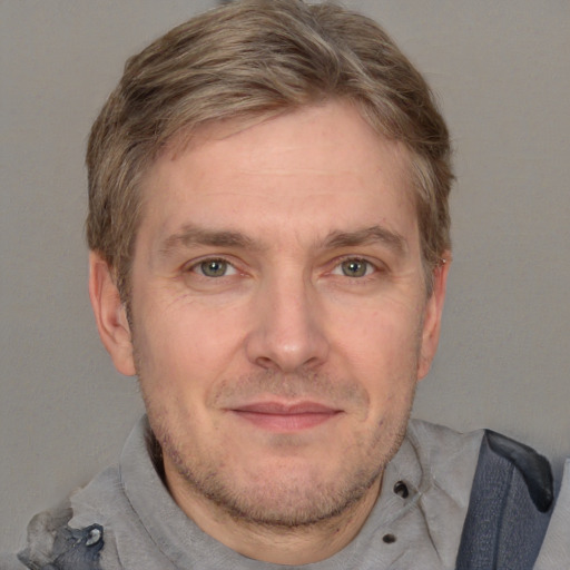 Joyful white adult male with short  brown hair and grey eyes