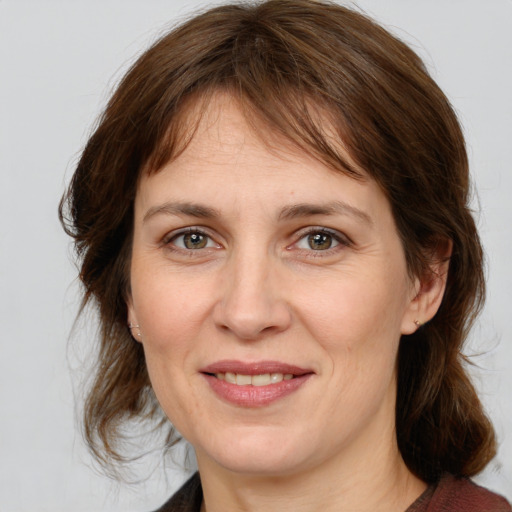 Joyful white adult female with medium  brown hair and grey eyes