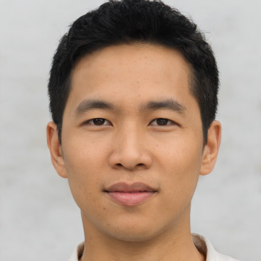 Joyful asian young-adult male with short  black hair and brown eyes