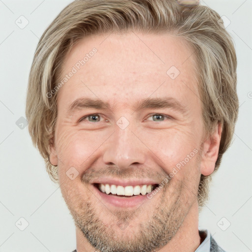 Joyful white young-adult male with short  brown hair and grey eyes