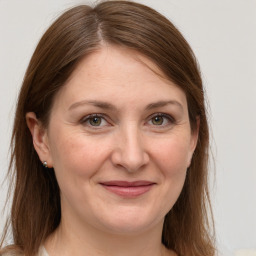 Joyful white adult female with long  brown hair and grey eyes