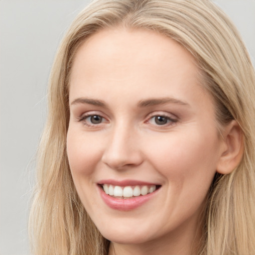 Joyful white young-adult female with long  brown hair and blue eyes