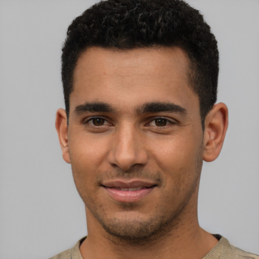 Joyful latino young-adult male with short  brown hair and brown eyes