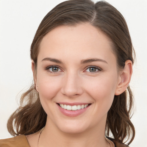 Joyful white young-adult female with medium  brown hair and grey eyes