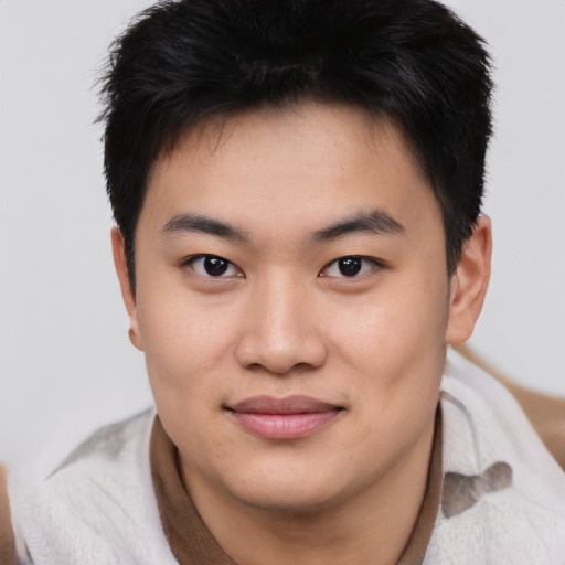 Joyful asian young-adult male with short  brown hair and brown eyes