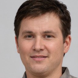 Joyful white adult male with short  brown hair and grey eyes