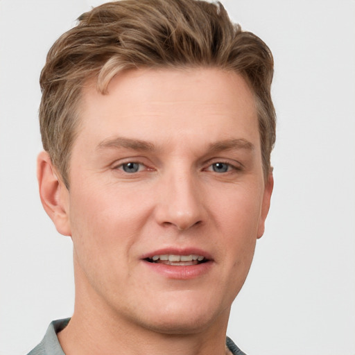 Joyful white young-adult male with short  brown hair and grey eyes