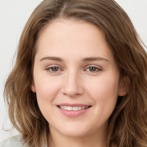 Joyful white young-adult female with long  brown hair and green eyes