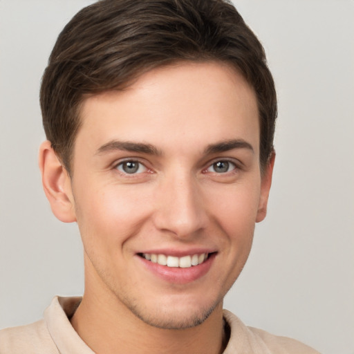 Joyful white young-adult male with short  brown hair and grey eyes