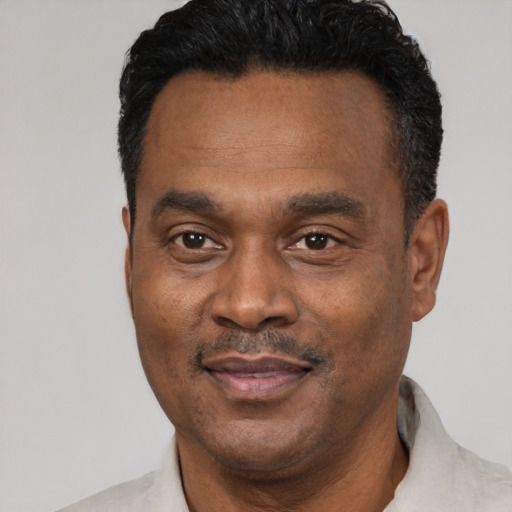 Joyful black adult male with short  black hair and brown eyes