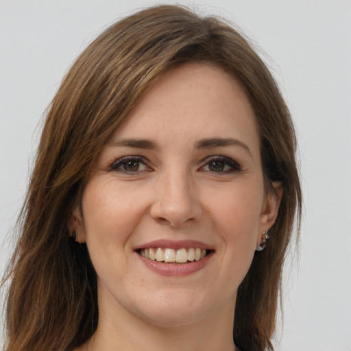 Joyful white young-adult female with long  brown hair and green eyes