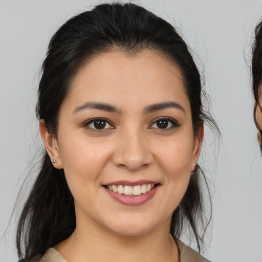 Joyful latino young-adult female with medium  brown hair and brown eyes