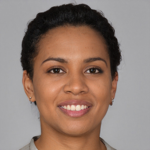 Joyful black young-adult female with short  brown hair and brown eyes