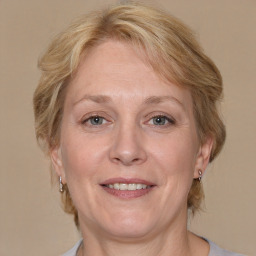 Joyful white adult female with medium  brown hair and blue eyes